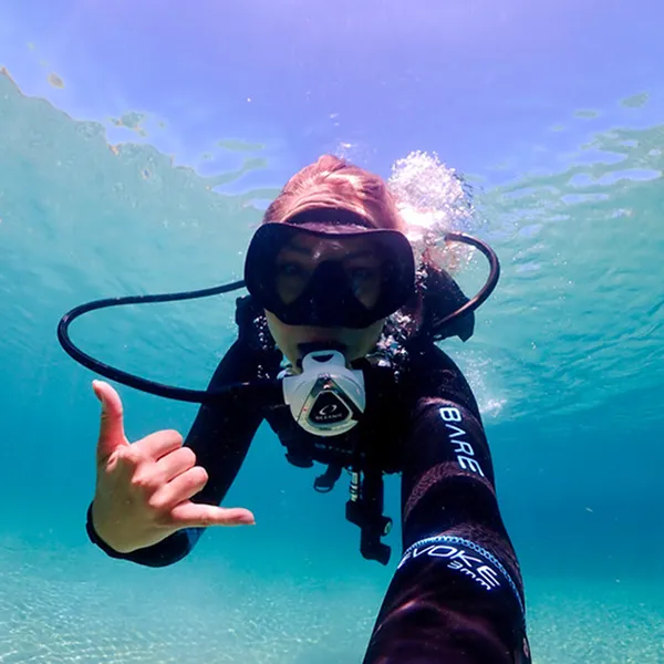 A first-time diver trying scuba with an instructor in Roatán on a cruise day